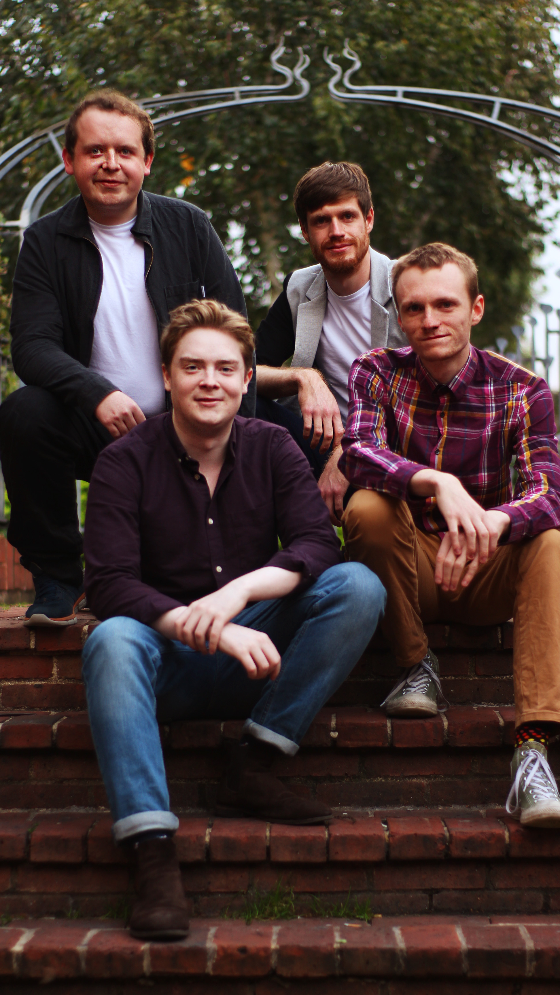 On That Note quartet sitting together on brick steps